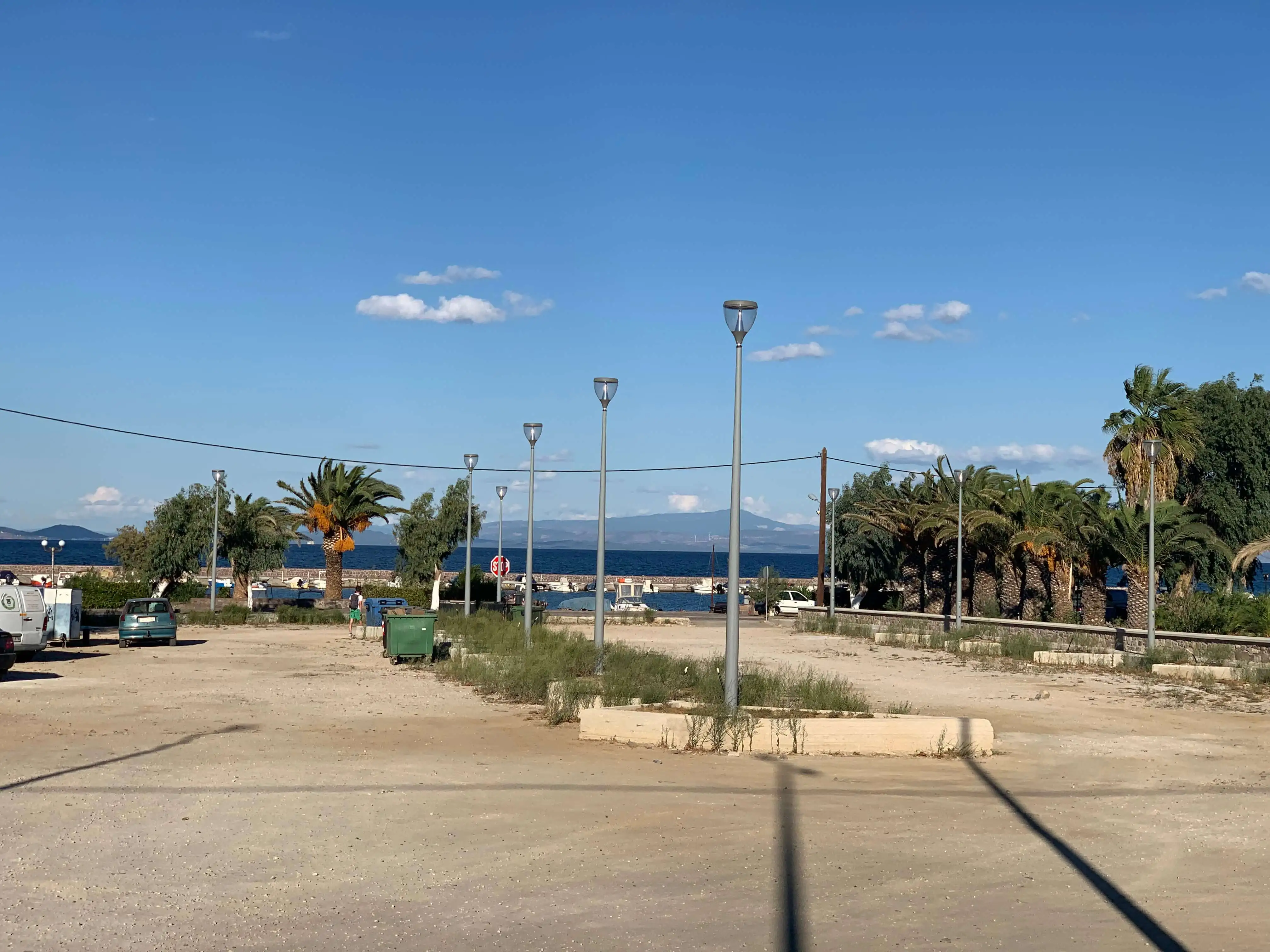 Απεικόνιση του χώρου πάρκινγκ, ο οποίος χωρίζεται από μια σειρά τεσσάρων ιστών φωτισμού και στη βάση του κάθε ιστού υπάρχει παρτέρι με φυτευμένα χόρτα.